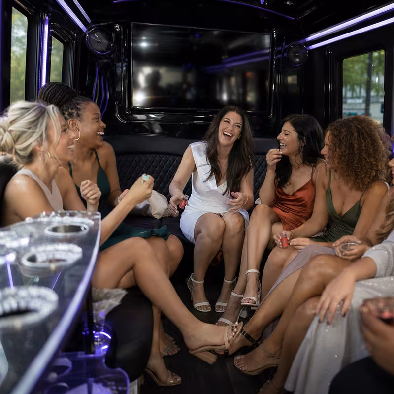 Party bus interior with wraparound leather seating and LED lighting in Greensboro