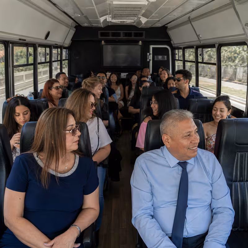 Group boarding a white charter bus for Private Event Transportation transportation in Greensboro
