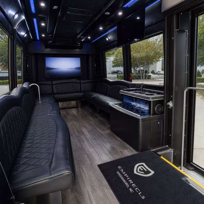 Party bus interior with wraparound leather seating and LED lighting in Greensboro