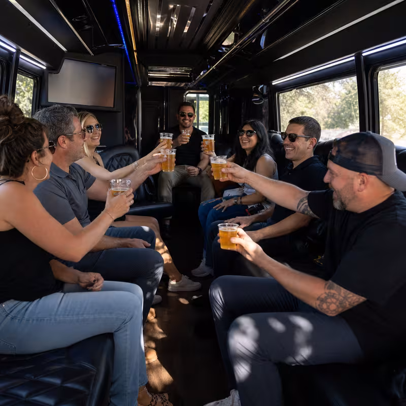 Group boarding a white charter bus for Winery & Brewery Tour Transportation transportation in Greensboro